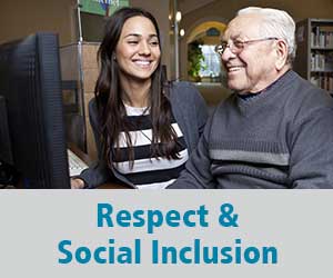Thumbnail image for Respect and Social Inclusion domain. Image is of a younger woman smiling at an older man who is looking at a computer screen.
