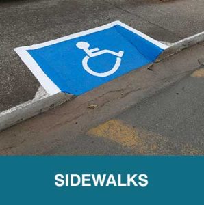 Thumbnail image of curb cut in sidewalk with blue-painted rectangular indicator and wheelchair icon. Caption is Sidewalks.